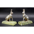 A pair of contemporary silver sculptures, each modelled realistically as a hare, in seated pose with... 
