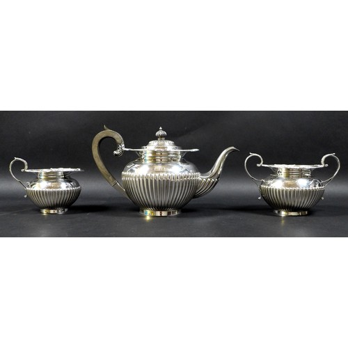 75 - A George V three piece silver tea service, of ovoid form with part reeded lower bodies and decorativ... 