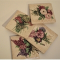 Set of 4 ceramic coasters with flower designs. 4 rubber cushion pads on bottom. Stored in display bo... 