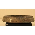 A shallow dish of bronze. It has Islamic writing around the outside and round an intricate pattern i... 