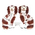 A pair of Victorian Staffordshire flatback fireside dogs, modelled as spaniels, each 25cm high. (2)