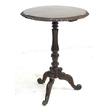 A late Victorian oak wine table, the circular surface with carved gadrooned edge, raised on a lappet... 