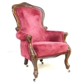A Victorian spoon back nursing chair, with carved top rail, raised on cabriole legs with castors, up... 