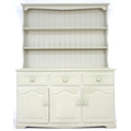 A modern pine pale green painted dresser, with plate rack over three drawers and three cupboards wit... 