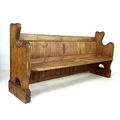 A 19th century pine pew with shaped ends and slatted back, 180 by 53 by 88cm high.