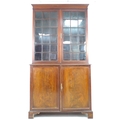 An Edwardian mahogany bookcase, with astragal glazed double doors, above a cupboard base, raised upo... 
