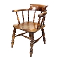 A Victorian oak smoker’s bow armchair, turned supports and shaped seat, with pale green buttoned vel... 