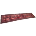 A Tekke rug with red ground, with central row of ten medallions, black decoration, 85 by 372cm.