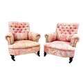 A pair of Victorian easy armchairs, in the style of Howard & Sons, upholstered in pink and grey flor... 
