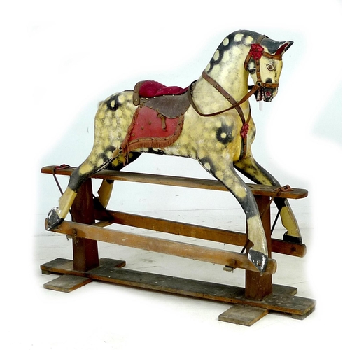 222 - A mid 20th century carved wooden rocking horse, dappled grey coat, red saddle, on a pine base with m... 