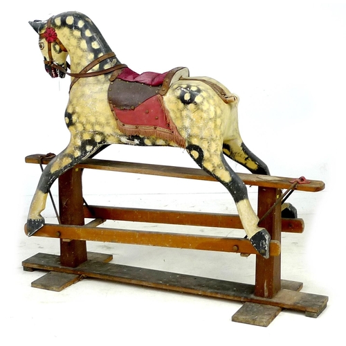 222 - A mid 20th century carved wooden rocking horse, dappled grey coat, red saddle, on a pine base with m... 