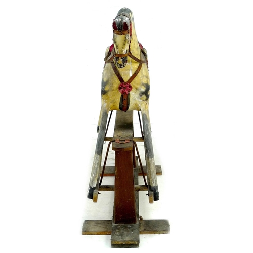 222 - A mid 20th century carved wooden rocking horse, dappled grey coat, red saddle, on a pine base with m... 