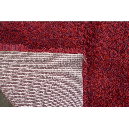 238 - A large contemporary 'Opus Shaggy' rug, with crimson ground, 245 by 345cm.