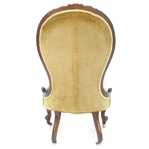 244 - A Victorian button back nursing chair, with walnut carved top-rail, upholstered in olive velvet, 75 ... 