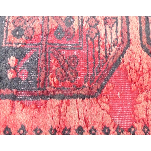 261 - A Tekke rug with red ground, with central row of ten medallions, black decoration, 85 by 372cm.