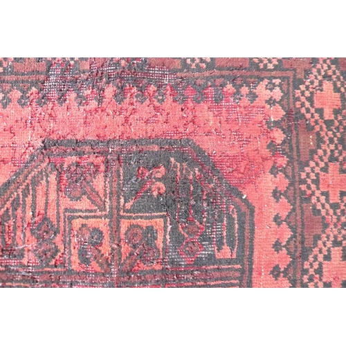 261 - A Tekke rug with red ground, with central row of ten medallions, black decoration, 85 by 372cm.