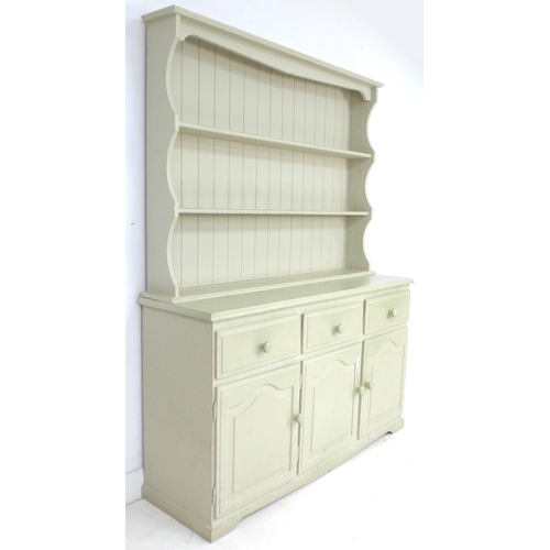 262 - A modern pine pale green painted dresser, with plate rack over three drawers and three cupboards wit... 