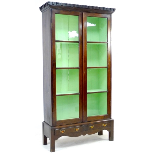 267 - A 20th century mahogany display cabinet, with double glazed doors, above a two drawer base with shap... 