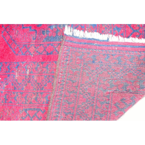 292 - A large Tekke rug with dark red and blue grounds, decorated with three rows of five elephants foot g... 