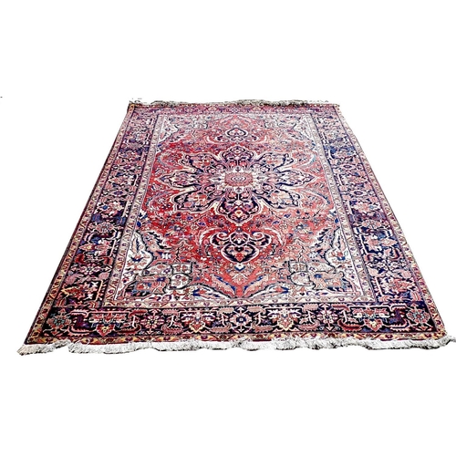 302 - A Heriz carpet with red ground, central cream and dark blue eight petalled medallion, with floral an... 