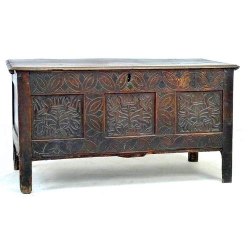 303 - An 18th century oak chest, lift top over a three panel front carved with foliate patterns and lunett... 