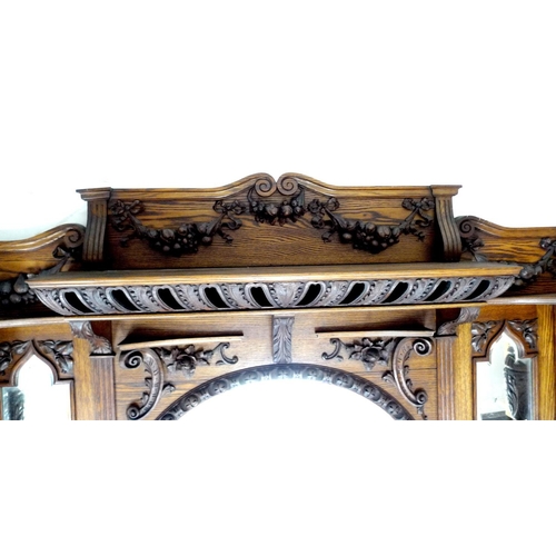 319 - An impressive mid 19th century oak fire surround, with an oval overmantel mirror and two smaller sha... 