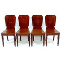 A set of four mahogany hall chairs by Holland & Sons, with squared shield shaped backs with circular... 