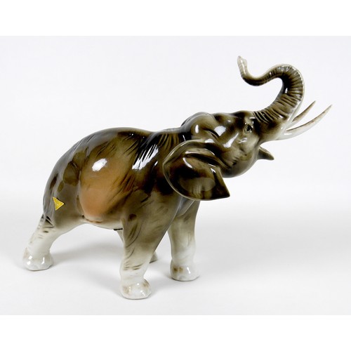 29 - A large Royal Dux figurine, modelled as an elephant, standing with upraised trunk, impressed model n... 