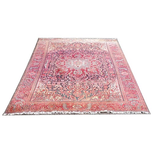 350 - A Heriz carpet with red ground, central cream, grey and red star shaped medallion, dark blue ground ... 