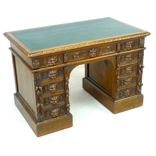 343 - An early 20th century oak twin pedestal desk, three frieze drawers, each pedestal with four drawers,... 