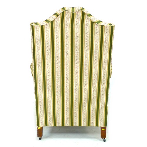 344 - An early 20th century Queen Anne style wing armchair, upholstered in striped dark green and gold flo... 