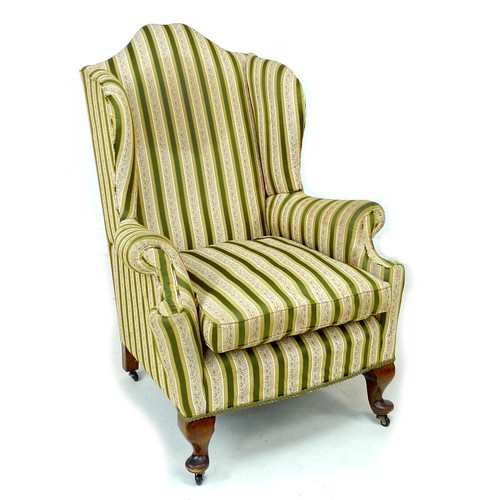 344 - An early 20th century Queen Anne style wing armchair, upholstered in striped dark green and gold flo... 