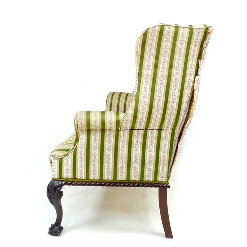 353 - A Victorian wing settee, two seater, high back, upholstered in striped dark green and gold floral em... 