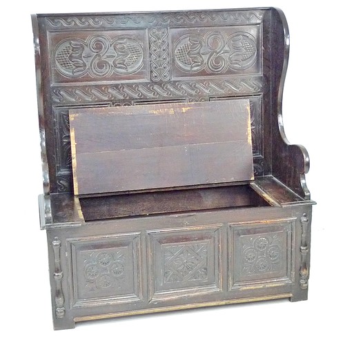 340 - A late Victorian oak settle, carved decoration, lift lid to the box seat, 125.5 by 51 by 137cm high.