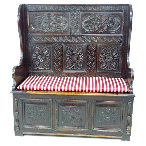 340 - A late Victorian oak settle, carved decoration, lift lid to the box seat, 125.5 by 51 by 137cm high.