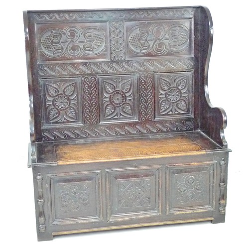 340 - A late Victorian oak settle, carved decoration, lift lid to the box seat, 125.5 by 51 by 137cm high.