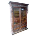 A late 19th century Continental oak bookcase, profusely carved with figures, leaves, and swags, with... 