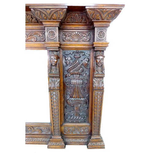 332 - A carved oak overmantel mirror, the bevelled rectangular plate flanked by carved panels and four bus... 