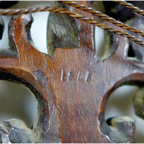 333 - A late 19th century Black Forest carved wall mirror, with oval plate, the framed carved as scrolling... 