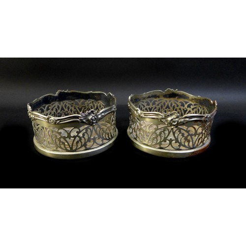 1 - A pair of silver plated bottle coasters, foliate pierced sides and applied ribbon and foliate rims, ... 