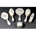 A group of six Victorian and Edwardian silver backed dressing table items, comprising a silver lidde... 