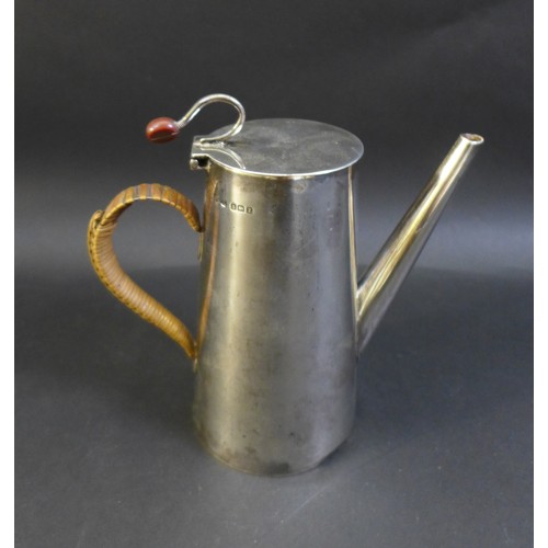 79 - A George V and VI silver coffee pot and hot water pot, the near pair both with flying coffee bean ti... 