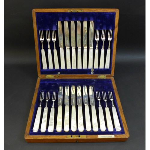 27 - A set of twelve Edwardian silver bladed fruit of dessert knives and forks, all with carved mother of... 