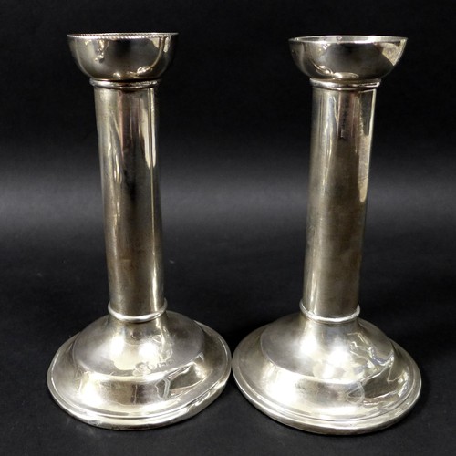 21 - A collection of silver and plated items including a pair of silver candlesticks, modernist form with... 