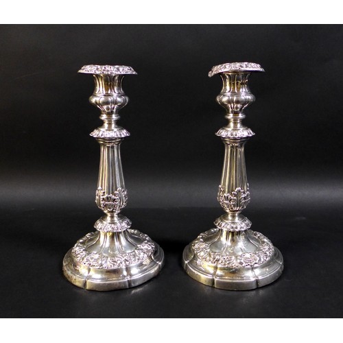 52 - A pair of 19th century Continental white metal candlesticks, the knopped reeded columns clasped with... 