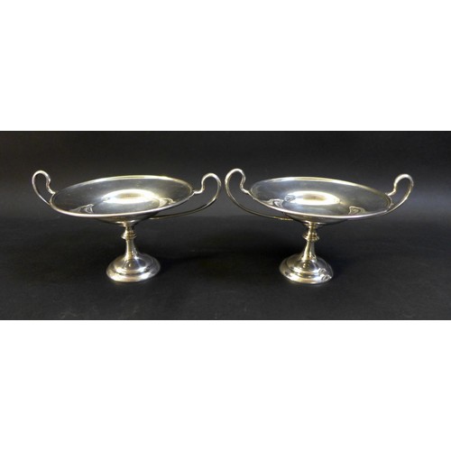 37 - A pair of George V twin handled silver bon bon dishes, raised upon circular stepped bases, both engr... 