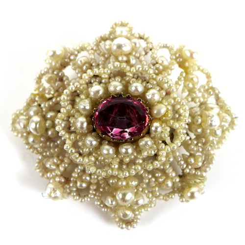 229 - A ruby, mother of pearl and seed pearl brooch, the central oval cut ruby of vibrant rose pink colour... 