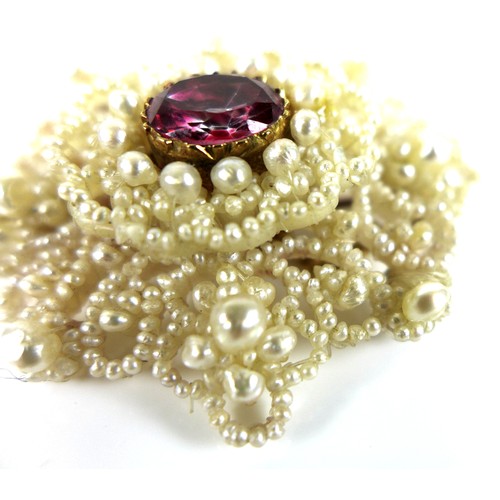 229 - A ruby, mother of pearl and seed pearl brooch, the central oval cut ruby of vibrant rose pink colour... 