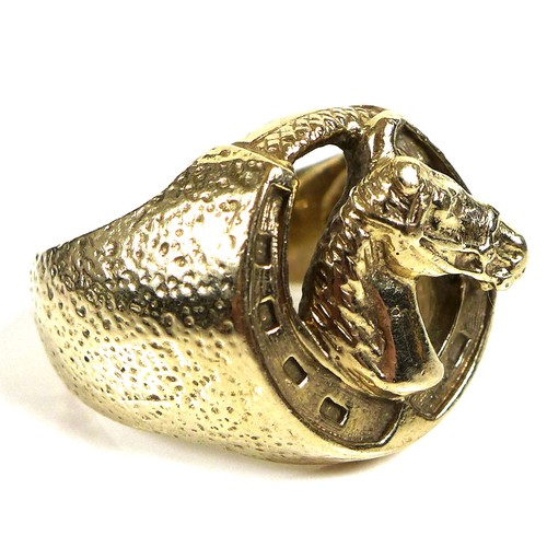 237 - A 9ct gold ring of large textured form, the central motif of a horse within a horseshoe, size Z, 29.... 