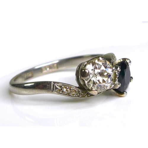 248 - An 18ct gold, platinum, diamond and sapphire 'Moi et Toi' crossover ring, the brilliant cut diamond,... 